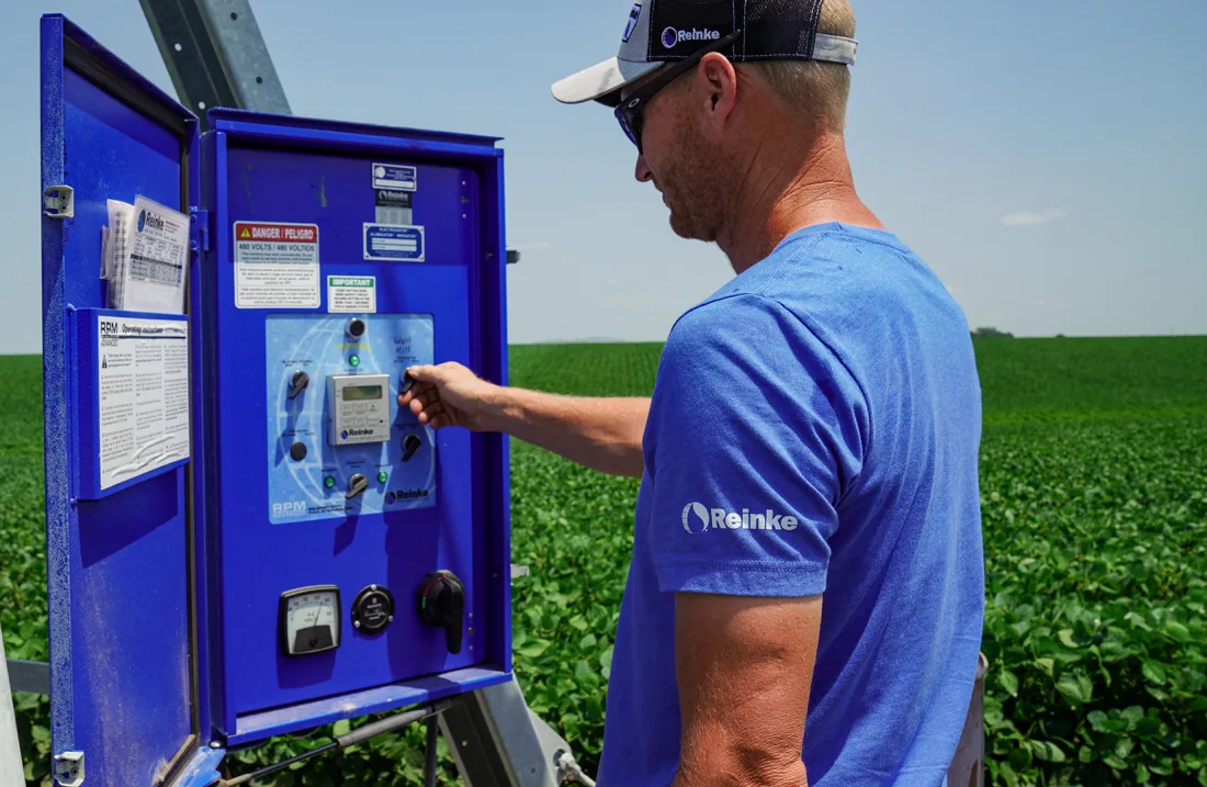 An operator working with a Reinke control panel in the field